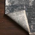 Rug corner flipped to reveal woven polypropylene backing and fringe detail