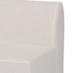 Close-up of bench's linen slipcover seam detail along rounded backrest edge.