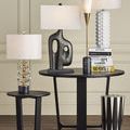 Martini Black Torchiere Table Lamp styled among other table lamps and artistic decor on black wood table