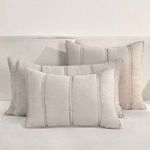 Three shams in matching taupe beige color styled on light beige sofa, showing layered living room setup