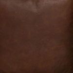 Close-up of distressed brown leather texture on chair's seating surface.