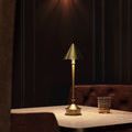 Traipse lamp displayed on marble table in dim room with brown seating and warm light from lamp shade diffuser