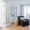 Botanical Garden I painting displayed in bright living room with dark armchair, wicker basket, and light hardwood floor