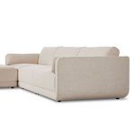 Angled side view highlighting rounded arm and loose back cushion with basketweave texture