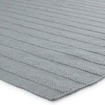 Close-up of textured sewn stripes and woven edges in sea green rug
