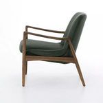 Side profile of chair emphasizing angled oak frame and deep leather seat