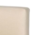 Interior corner of bed frame showing metal supports and cream linen slipcover