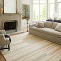 Chris Natural / Multi Rug in living room with neutral sofa, chair, and fireplace, showing rug's size and room styling