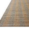 Low angle view showing rug’s textured weave and blue-striped pattern with natural fiber details