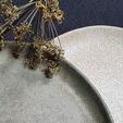 Two Mame Dessert Plates side by side with dried flowers, showing speckled surface textures in green and beige tones