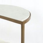 Detail of antique brass frame corner joint and edge of polished white marble shelf