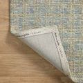 Polly Blue Sand Rug corner flipped over revealing branded fabric backing