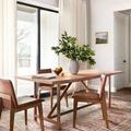 Heidi rug under dining table with brown leather chairs set in a sunlit room with curtains and wall art