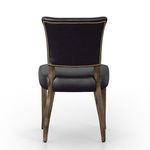 Back view of chair with black leather, curved backrest, and decorative gold nailhead trim
