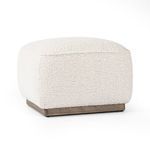 Side angle view showing rounded top cushion and wood base of ottoman