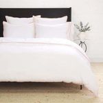 Bedroom setting with multiple Langston Bamboo Sateen Euro shams styled on bed with black headboard