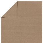 Back side folded over showing reverse side and thin profile of the brown woven rug