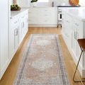 Long runner view of Lila rug placed in a white kitchen with light hardwood flooring and modern cabinetry