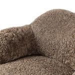 Close-up showing detailed taupe shearling fabric and cushioned backrest curve
