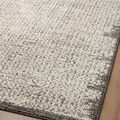 Angled view of rug surface on wood floor showing ribbed texture and gradient border