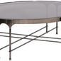 Calliope Cocktail Table angled view showing curved apron and cross-base metal legs with square feet