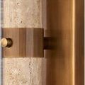 Close-up of antique brass band and knob fastening the travertine column to the wall plate