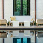 Outdoor scene with Palma sofa styled by pool, featuring decorative pillows and matching ottomans