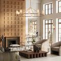 Chandelier with tan linen shades viewed within an elegant living room featuring high ceilings