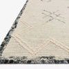 Close-up angled view showing thick wool pile texture and blue-grey speckled reinforced border
