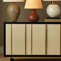 Sideboard with woven raffia door fronts styled with three ceramic table lamps in warm tones