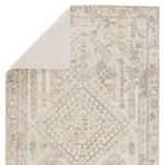 Top corner of Arlowe rug folded over to reveal plain light beige backing material