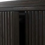 Close-up of ribbed front door edge with door slightly ajar revealing mechanism.