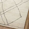 Close view of Fabian Rug diamond pattern and textured pile on wood floor