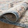 Close-up of rug edge rolled to reveal fabric backing and detailed weave