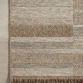 Partial top view showing offset stripe pattern and fringe on one short edge against a beige floor