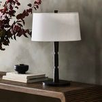 Fernando Table Lamp styled with plant and decorative objects on wooden table with textured wall