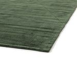 Close-up showing rug corner’s clean edge and soft plush texture in muted green
