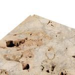 Detailed close-up of travertine top with natural pockmarked texture and light tan hues