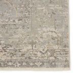 Close-up of the rug corner with visible fringe tassels and detailed mosaic weaving in neutral tones