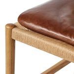 Detailed close-up of leather cushion and woven natural cord wrapped chair leg