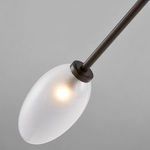 Close-up side view of one lit frosted oval shade with its black brass frame holder