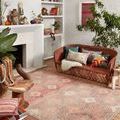 Malik Dove Sunset Rug styled in a bohemian living room with rust-colored sofa and colorful pillows