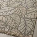 Angled view highlighting woven sisal-like texture and tonal beige leaf pattern