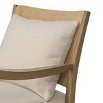Angled close-up showing plush beige pillow leaning against wood backrest on Godfrey Chair