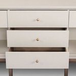 Frontal close-up of three fully extended drawers displaying interior wood finish