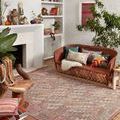 Malik Berry Multi Rug styled in bohemian living room with rust sofa and plants