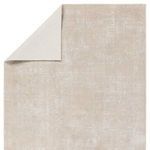 Rug corner folded to reveal light-colored backing contrasting with the patterned front