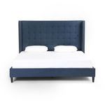 Front view of bed showcasing symmetrical button tufting on indigo linen headboard