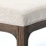 Macro shot of wood grain texture on chair frame beside soft fabric upholstery