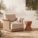 Meredith Outdoor Accent Chair styled outdoors on tiled patio with small side table and throw blanket